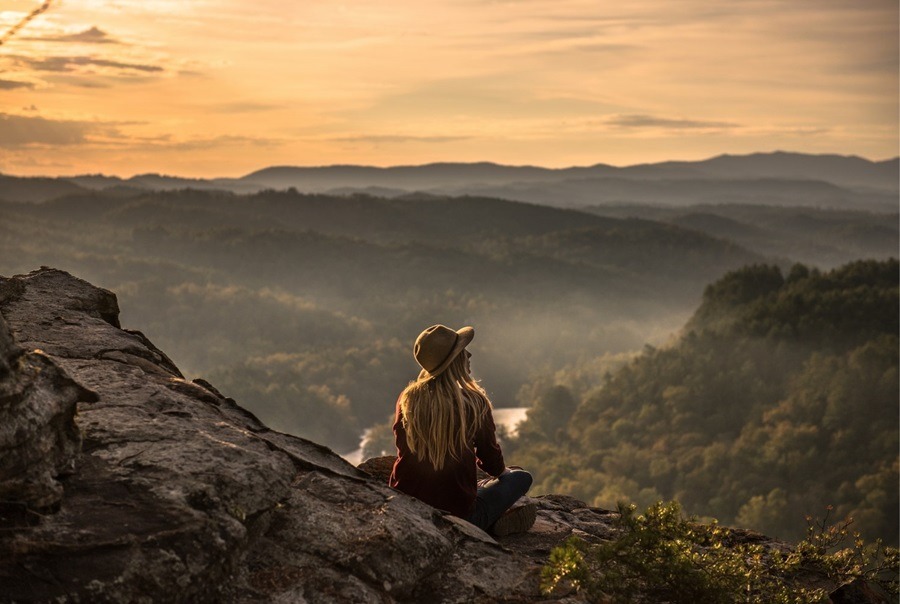 Frau sitzend in den Bergen, Aussicht auf Umgebung und Natur, Ängste vorm Alleinreisen